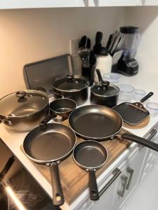 a group of pots and pans on a stove at Brand New 4 bedroom Villa by Hamilton Airport! in Hamilton