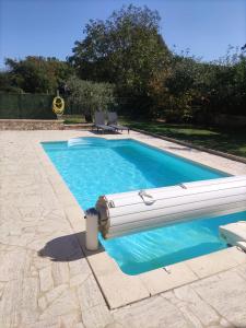 a swimming pool with blue water in a yard at Appartement Jas du Cassoir BRAS-D'ASSE in La Bégude-Blanche