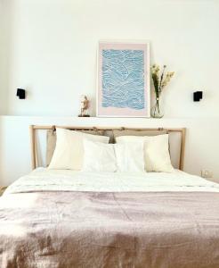 ブカレストにあるUrban Parkside Retreat Cozy 2-Bed Ap by Metroの白いシーツと花瓶が備わるベッド