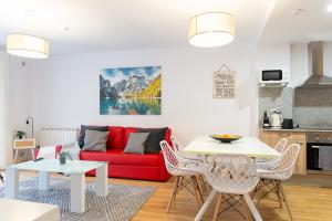 a living room with a red couch and a table at AndBnB I Apartamento con Terraza y Parking in Arinsal