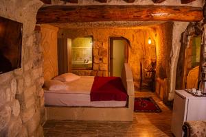 a bedroom with a bed in a stone wall at Junior Ottoman Cave in Ürgüp