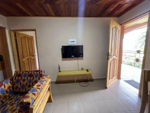 a living room with a couch and a tv on the wall at RKS - Résidence Kribi Soleil in Kribi