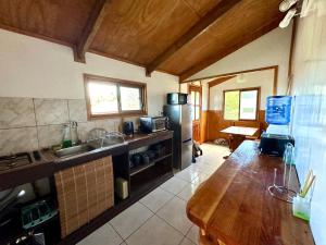 cocina con encimera de madera y nevera en PARAÍSO Sunset Bungallows, en Hanga Roa