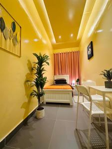 a yellow room with a bed and a table at Sunrise Inn by DSV Property in Abu Dhabi