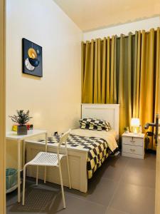 a small bedroom with a bed and a desk at Sunrise Inn by DSV Property in Abu Dhabi