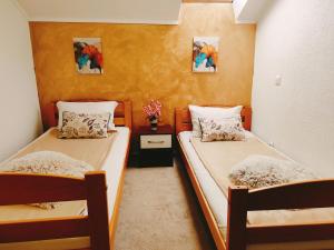 two beds in a small room with yellow walls at SKY APARTMENT SARAJEVO in Sarajevo