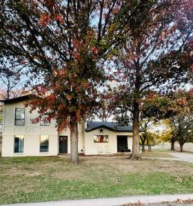a white house with two trees in front of it at The House of Serenity: Close to Fort Sill & Casino in Lawton