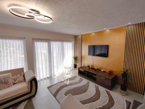 a living room with a couch and a flat screen tv at SKY APARTMENT SARAJEVO in Sarajevo