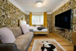 a living room with a couch and a flat screen tv at Deluxe 1 Bed Versace Hot Tub Sky TV Cinema Screen in Great Sampford