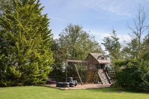 a playground in a yard with a play house at Deluxe 1 Bed Flat Hot Tub Sky Tv in Great Sampford
