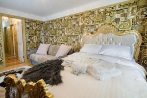 a bedroom with a white bed and a couch at Deluxe 1 Bed Versace Hot Tub Sky TV Cinema Screen in Great Sampford