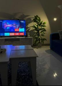 ein Wohnzimmer mit einem TV und einem Couchtisch in der Unterkunft الجود مخيم شقة استراحة بيت in Chamis Muschait