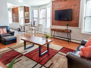 ein Wohnzimmer mit Couchtisch und Ziegelwand in der Unterkunft Spacious Getaway by Wooster Square! in New Haven