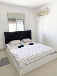 1 dormitorio con 1 cama grande y cabecero negro en Spacious penthouse with terrace, en Nahariyya