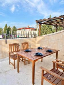 a wooden table and chairs on a patio at Spacious penthouse with terrace in Nahariyya