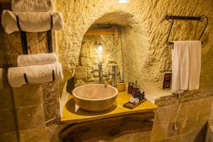 a bathroom with a large bowl sink in a stone bathroom at Junior Ottoman Cave in Ürgüp