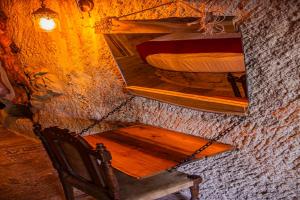 a wooden chair and a mirror on a wall at Junior Ottoman Cave in Urgup