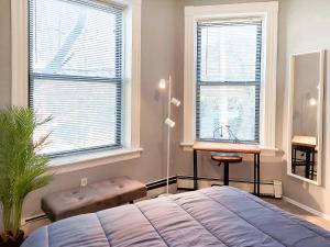 1 Schlafzimmer mit einem Bett, einem Schreibtisch und 2 Fenstern in der Unterkunft Spacious Getaway by Wooster Square! in New Haven