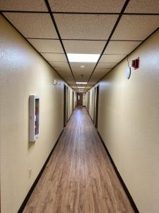 a hallway in an office building with a wooden floor at American Inn-Alexander City in Alexander City