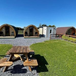 a picnic table in a yard with two huts at Emlagh, Self Catering Glamping Pods in Kilkee