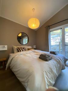 sypialnia z dużym białym łóżkiem i dużym oknem w obiekcie Tinyhouse Grasmus w mieście Nunspeet