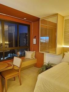 - une chambre avec un lit, une table et une fenêtre dans l'établissement Studio com vista do Mar em Salvador/Ba, à Salvador