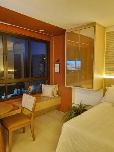 - une chambre avec un lit, un bureau et une fenêtre dans l'établissement Studio com vista do Mar em Salvador/Ba, à Salvador