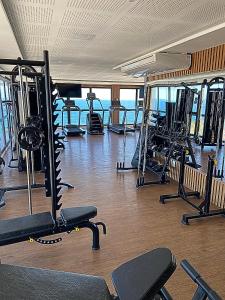une salle de sport avec plusieurs tapis de course et machines dans l'établissement Studio com vista do Mar em Salvador/Ba, à Salvador