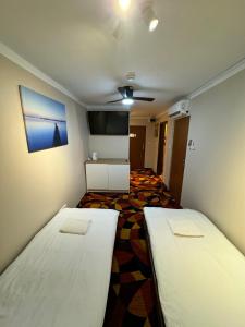 a room with two beds and a flat screen tv at okuninkapokoje in Okuninka