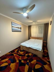 um quarto com uma cama e uma ventoinha de tecto em okuninkapokoje em Okuninka