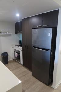 a kitchen with a black refrigerator and a stove at Ground Floor Luxury Oceanfront Apartment in Bargara