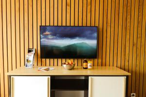 een flatscreen-tv op een houten muur met een tafel bij Peak view - 4 persons in Leytron
