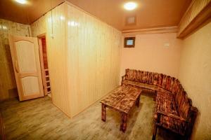 a room with a wooden bench and a table in it at Hotel Samta in Tskaltubo