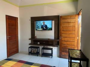 a living room with a television on a wall at Casa no francês! in Marechal Deodoro