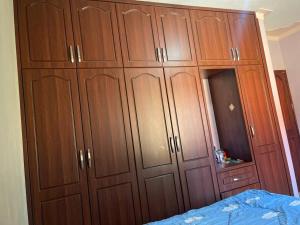 1 dormitorio con armarios de madera y 1 cama en Calm Haven: Your Private Retreat, en Kira