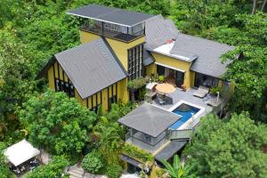 una vista aérea de una casa amarilla con piscina en Butterfly Garden Villa, en Laem Set Beach