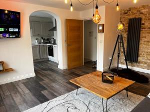 a living room with a table and a kitchen at Sterling Stylish 2 bedroom Central Modern Apartment in Darlington