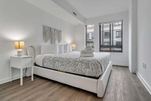 a white bedroom with a bed and a window at 2BR Furnished Apartment Near Nationals Park in Washington