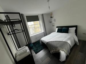 a white bedroom with a bed and a window at Sterling Stylish 2 bedroom Central Modern Apartment in Darlington