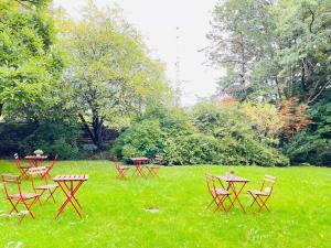 een groep tafels en stoelen in het gras bij aday - Aalborg Mansion - Charming 3 Bedroom Apartment in Aalborg