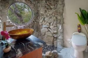 y baño con lavamanos y aseo. en Riverfront & Jacuzzi. 8th wonder of the world., en Rivas