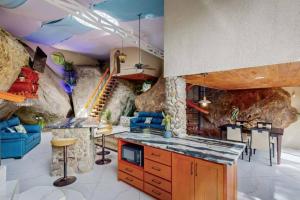una cocina con una habitación con una pared de roca en Riverfront & Jacuzzi. 8th wonder of the world., en Rivas