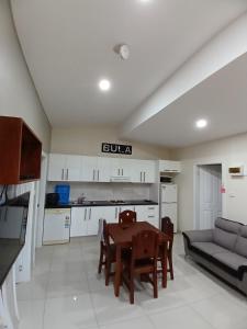 uma cozinha e sala de estar com uma mesa e um sofá em New Door Apartments em Nadi
