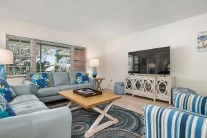 ブレーデントンにあるSwaying Palms! Coastal home with amazing pool just a short drive from Anna Maria Island!のソファとテレビのあるリビングルーム