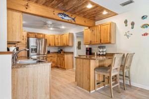 ブレーデントンにあるSwaying Palms! Coastal home with amazing pool just a short drive from Anna Maria Island!の木製のキャビネットとカウンタートップを備えたキッチン