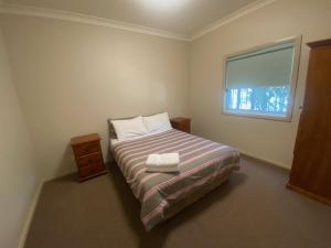 una piccola camera con letto e finestra di Airfield Tourist Park Temora a Temora