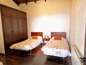 Un dormitorio con dos camas y un armario de madera. en Casa Canaria Drago in Icod de los Vinos, en Icod de los Vinos