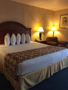 a hotel room with a large bed and a chair at Hotel Pentagon in Arlington