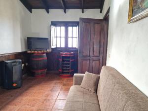 sala de estar con sofá y algunos barriles en Casa Canaria Drago in Icod de los Vinos, en Icod de los Vinos