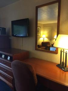 a hotel room with a desk with a mirror and a television at Hotel Pentagon in Arlington